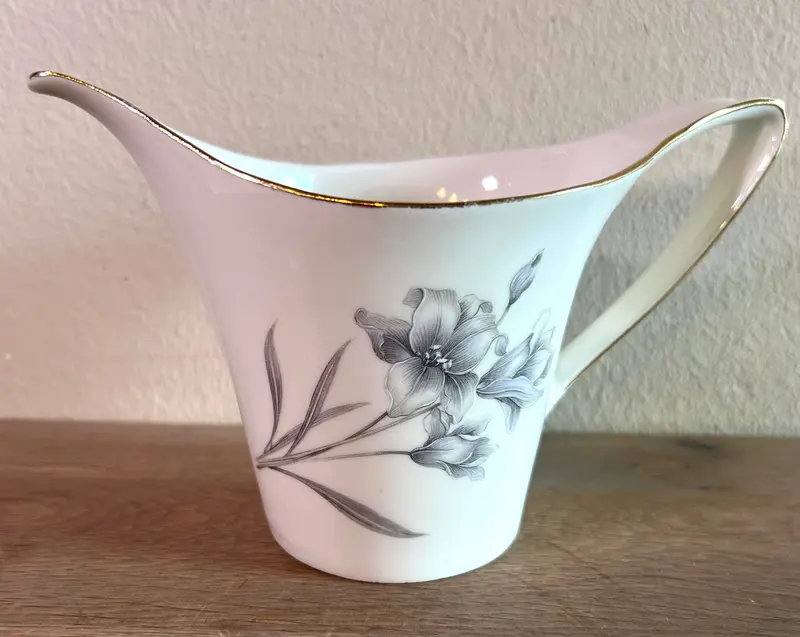 Melkkan - Boch Porcelaine - uitgevoerd in wit porselein met een decor van bloemen in grijs/lila en goudkleur randen